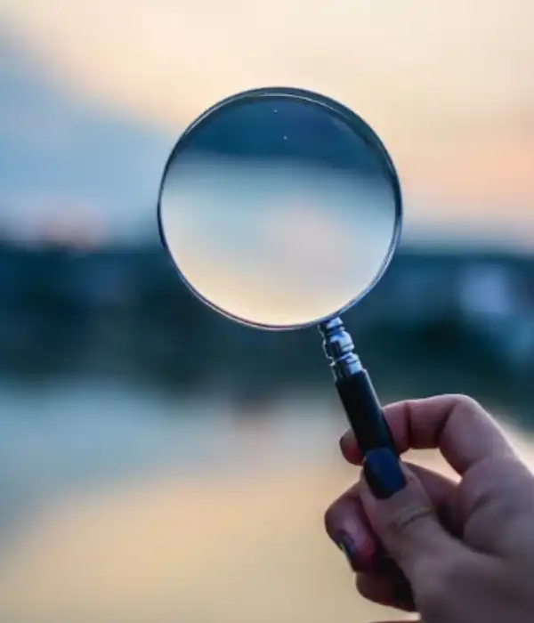 A hand's holding a magnifying glass up to the horizon.